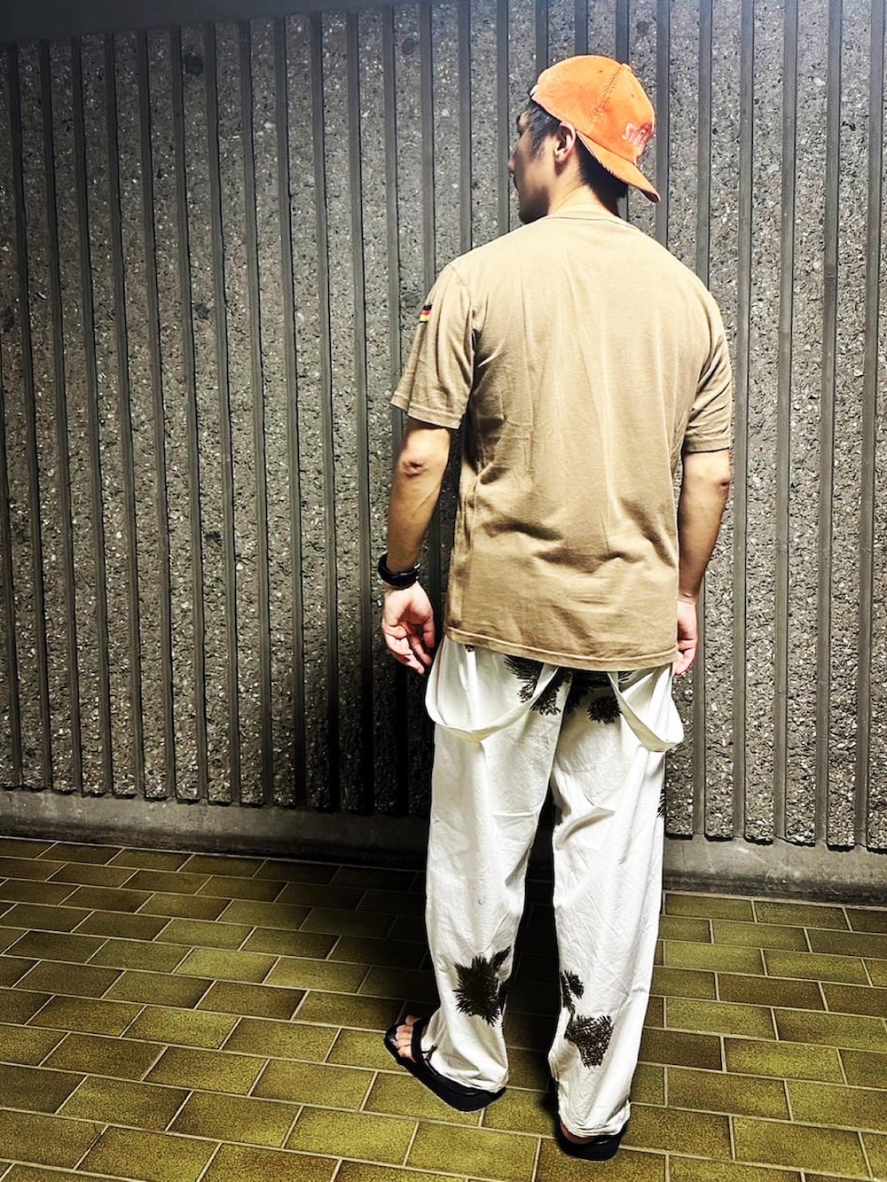 ブラウン系のTシャツ/カットソー、ホワイト系のその他パンツ、オレンジ系のキャップを着用したメンズの夏コーディネートの2枚目の写真