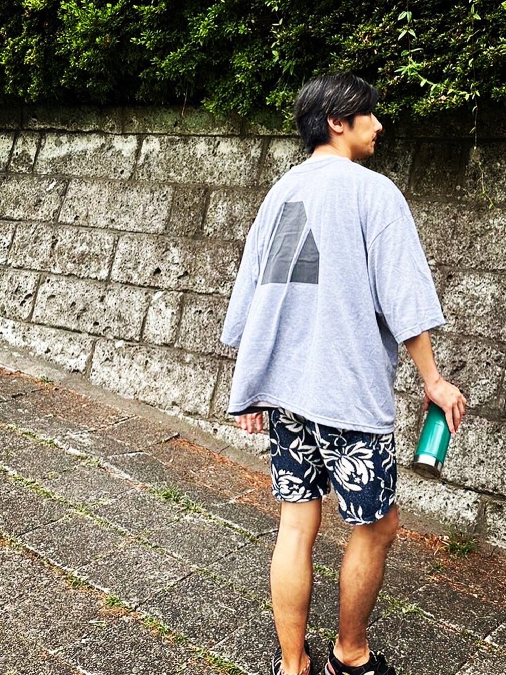 グレー系のTシャツ/カットソー、ブルー系のその他パンツ、ブラック系のサンダルを着用したメンズの夏コーディネートの3枚目の写真