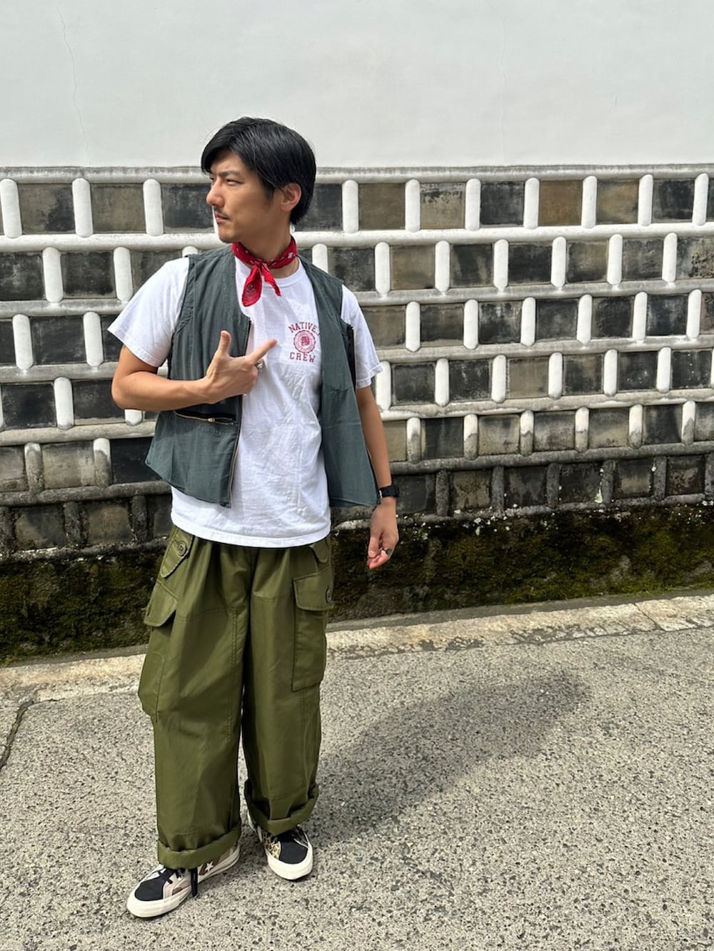 ブラック系のスニーカー、グリーン系のカーゴパンツを着用したメンズの夏コーディネートの2枚目の写真