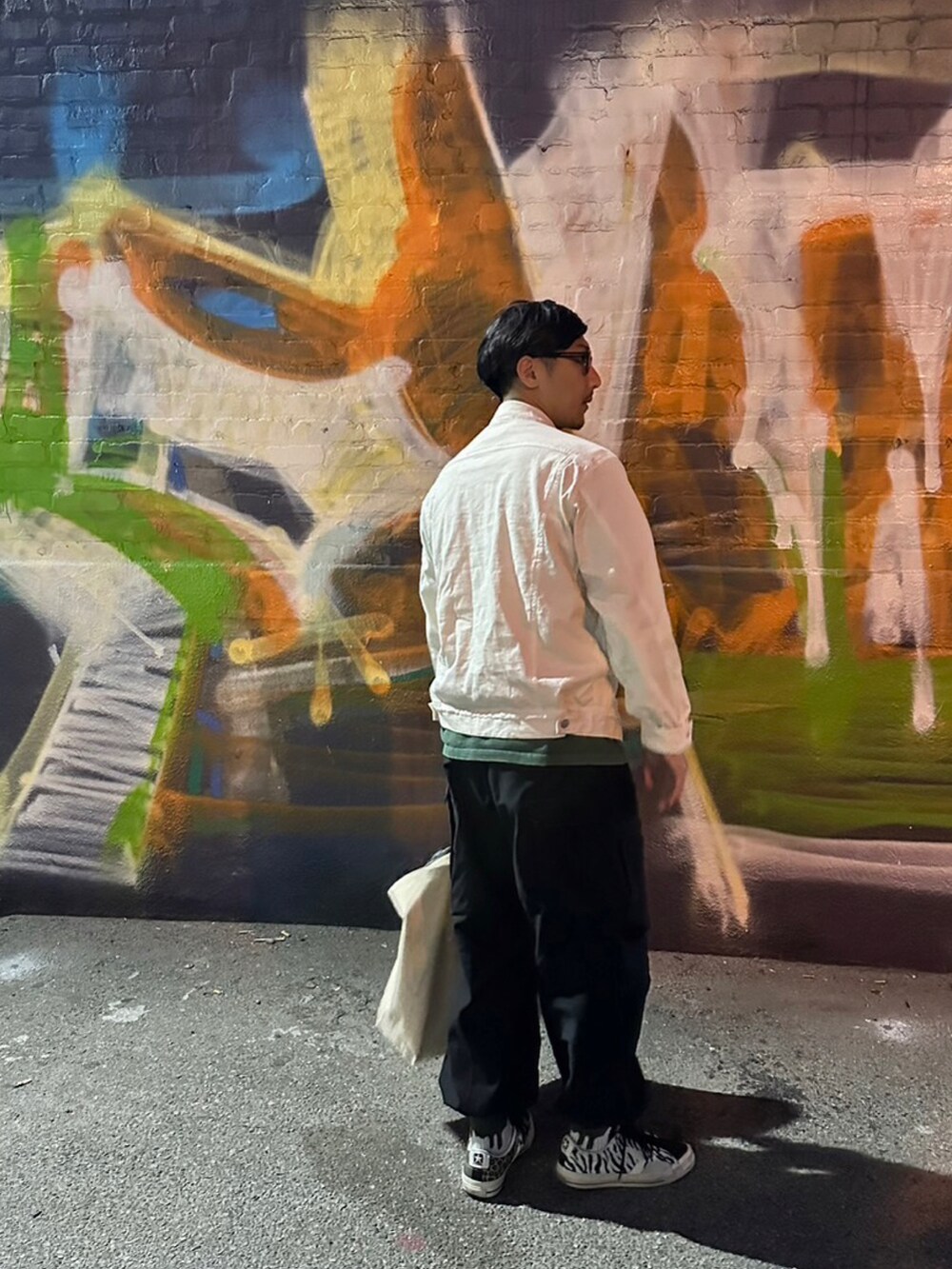 ホワイト系のジャケット/アウター、ブラック系のカーゴパンツ、ブラック系のスニーカーを着用したメンズの秋コーディネートの3枚目の写真