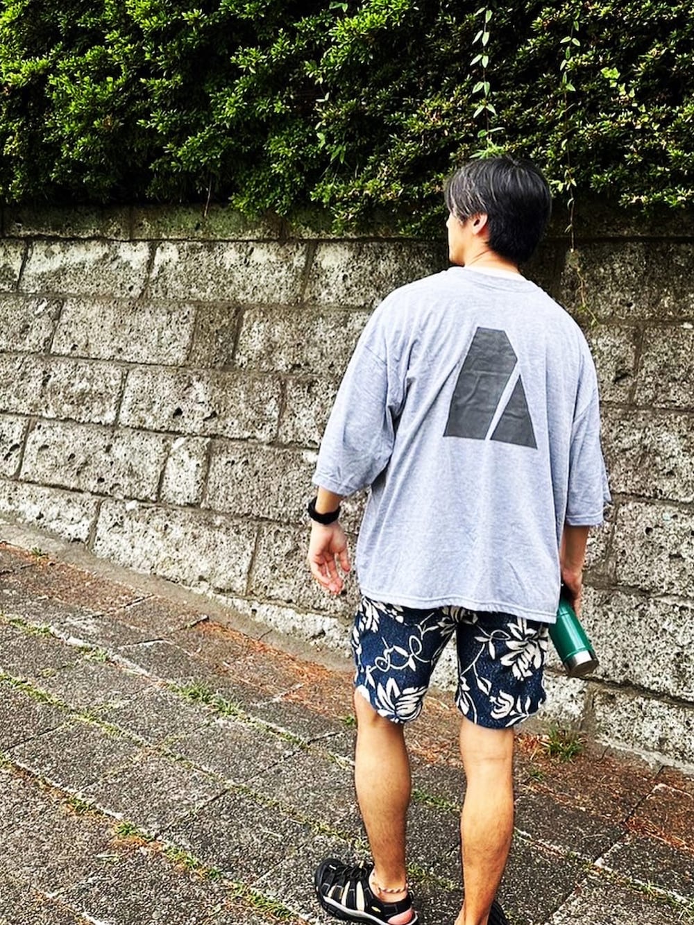 グレー系のTシャツ/カットソー、ブルー系のその他パンツ、ブラック系のサンダルを着用したメンズの夏コーディネートの2枚目の写真