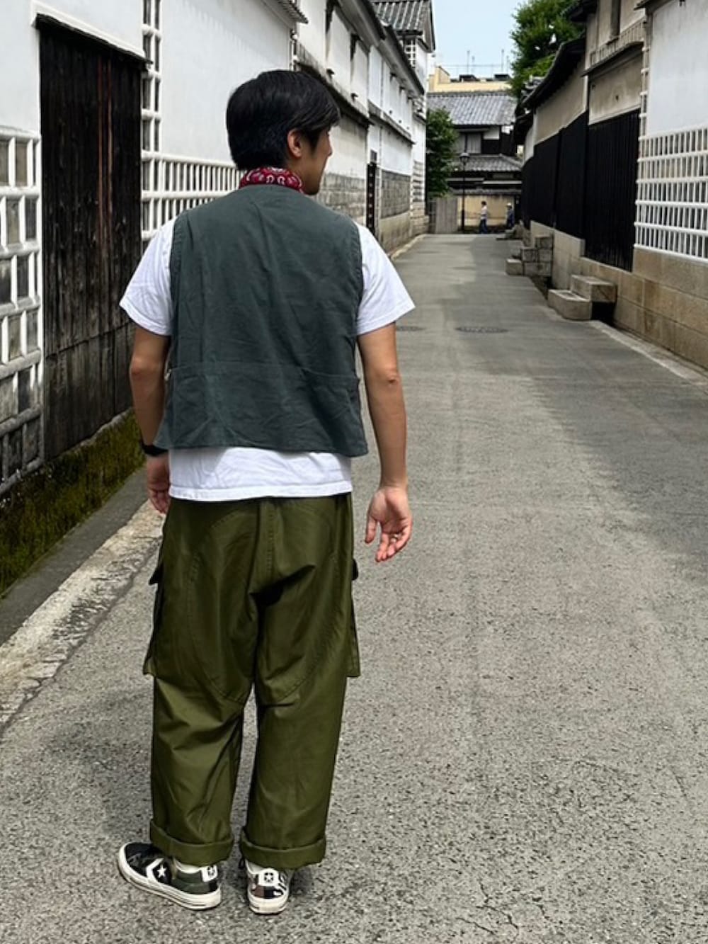 ブラック系のスニーカー、グリーン系のカーゴパンツを着用したメンズの夏コーディネートの3枚目の写真