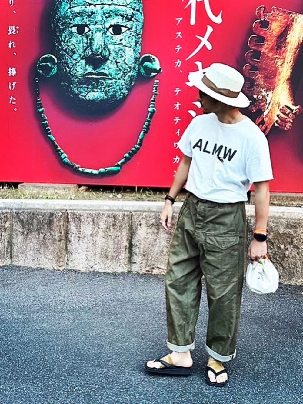 ホワイト系のTシャツ/カットソー、グリーン系のデニムパンツ、ホワイト系のハットを着用したメンズの秋コーディネートの2枚目の写真