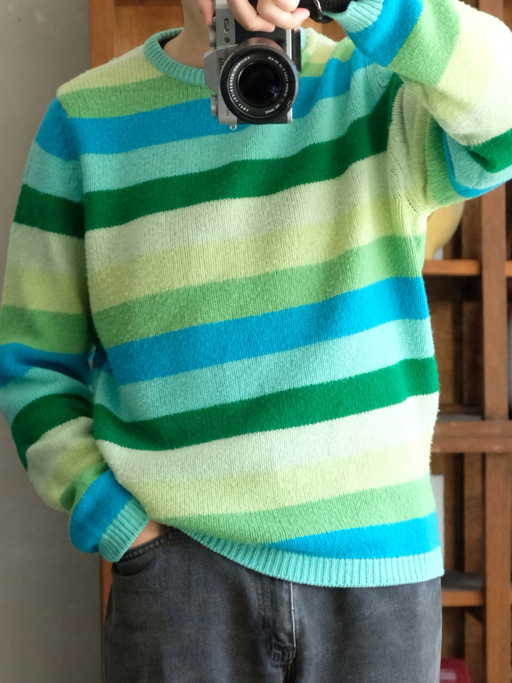 ブルー系のニット/セーター、ブラック系のテーラードジャケット、ブラック系のデニムパンツを着用したメンズの秋コーディネートの2枚目の写真