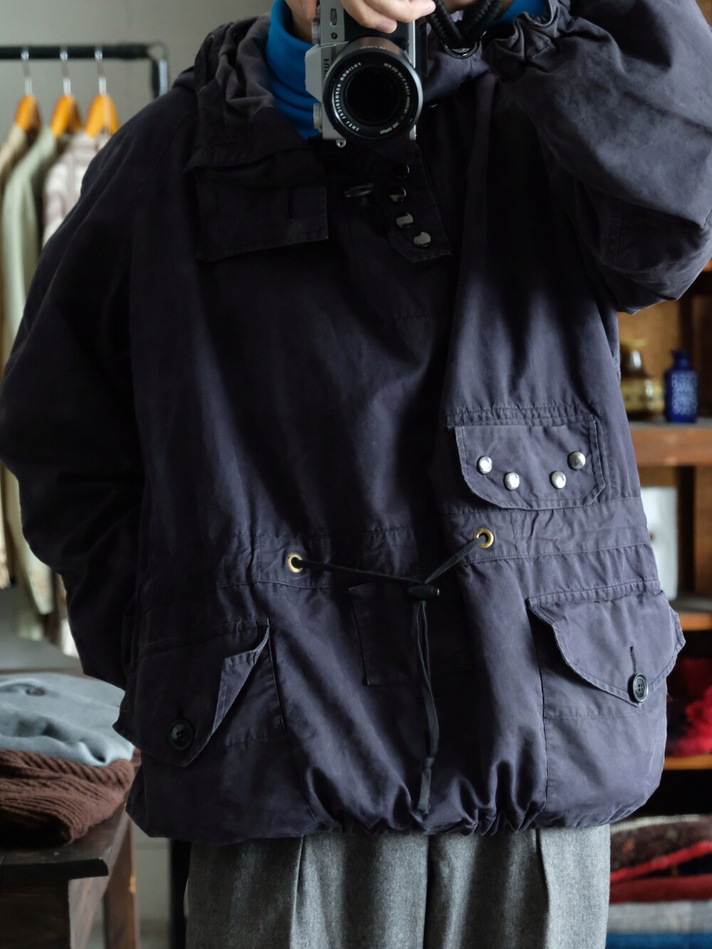 ブルー系のTシャツ/カットソー、ブルー系のミリタリージャケット、グレー系のスラックスを着用したメンズの秋コーディネートの2枚目の写真