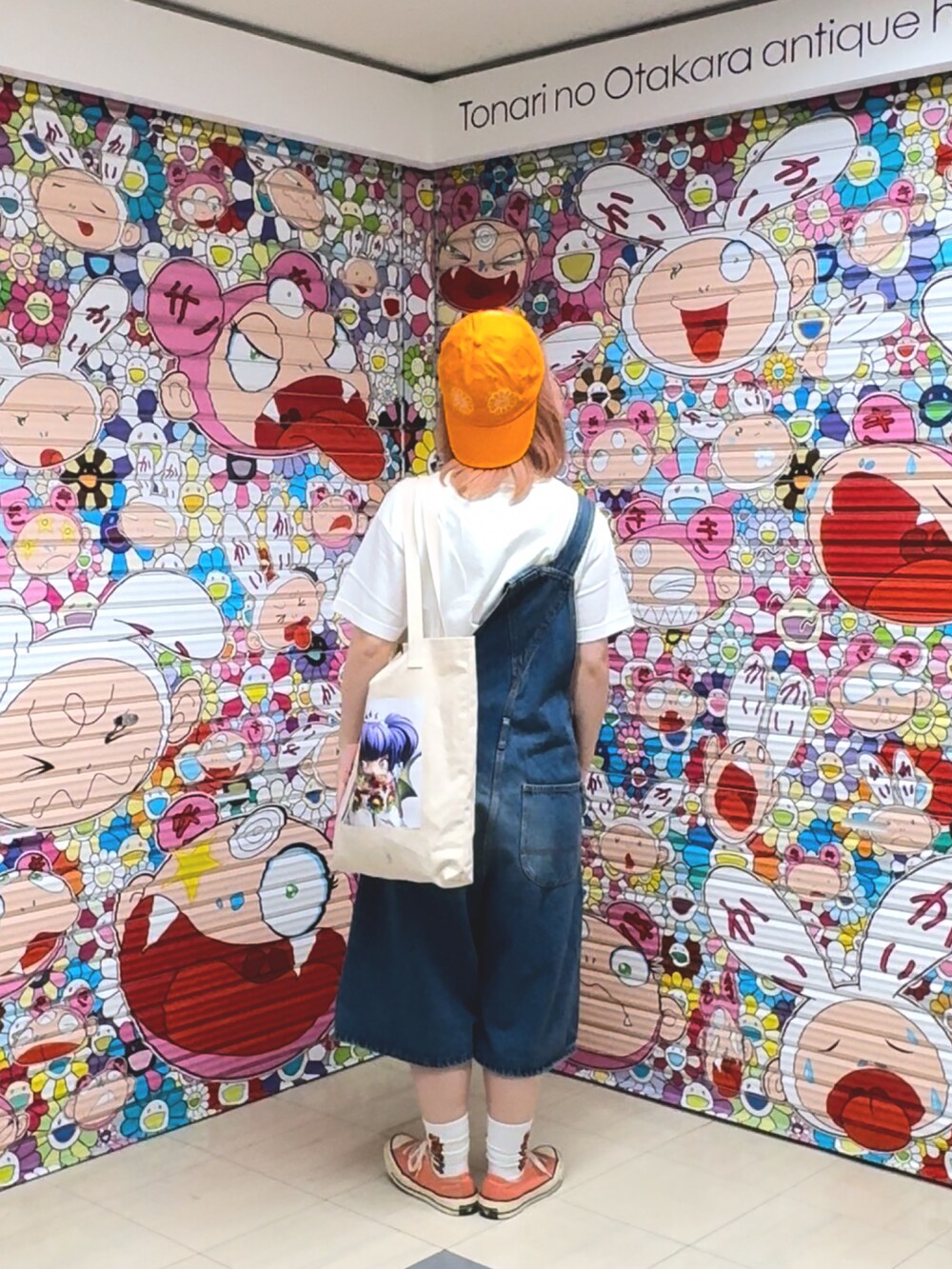 オレンジ系のスニーカー、ブルー系のサロペット/オーバーオール、ホワイト系のトートバッグを着用したレディースの秋コーディネートの2枚目の写真