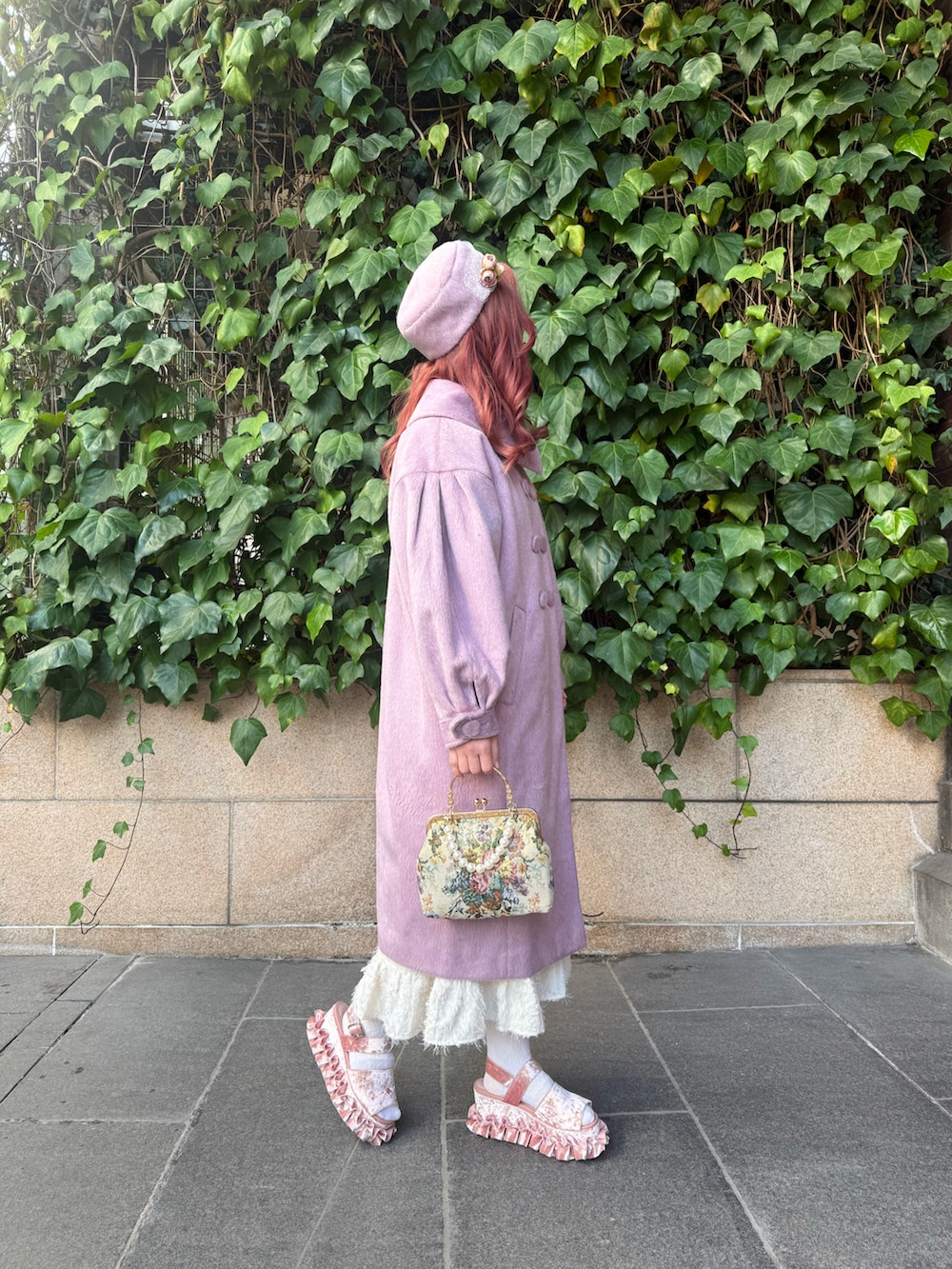 ピンク系のサンダル、ホワイト系のワンピース、その他のハンドバッグを着用したレディースの冬コーディネートの2枚目の写真