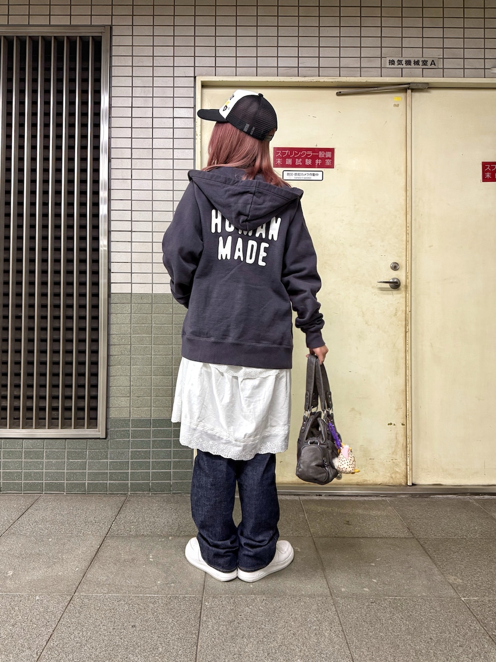 ホワイト系のスニーカー、ブラック系のTシャツ/カットソー、ブラック系のパーカーを着用したレディースの冬コーディネートの2枚目の写真