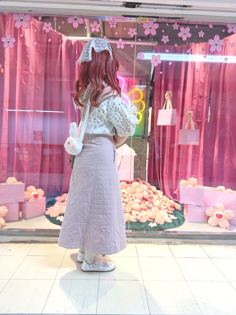 ピンク系のスカート、ホワイト系のスニーカー、その他のカーディガン/ボレロを着用したレディースの冬コーディネートの2枚目の写真