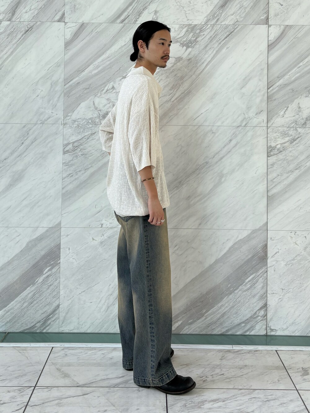 ブルー系のデニムパンツ、ホワイト系のポロシャツを着用したメンズの夏コーディネートの2枚目の写真