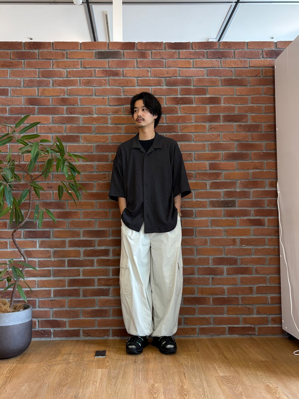 グレー系のシャツ/ブラウス、ホワイト系のカーゴパンツ、ブラック系のサンダルを着用したメンズの春コーディネートの2枚目の写真