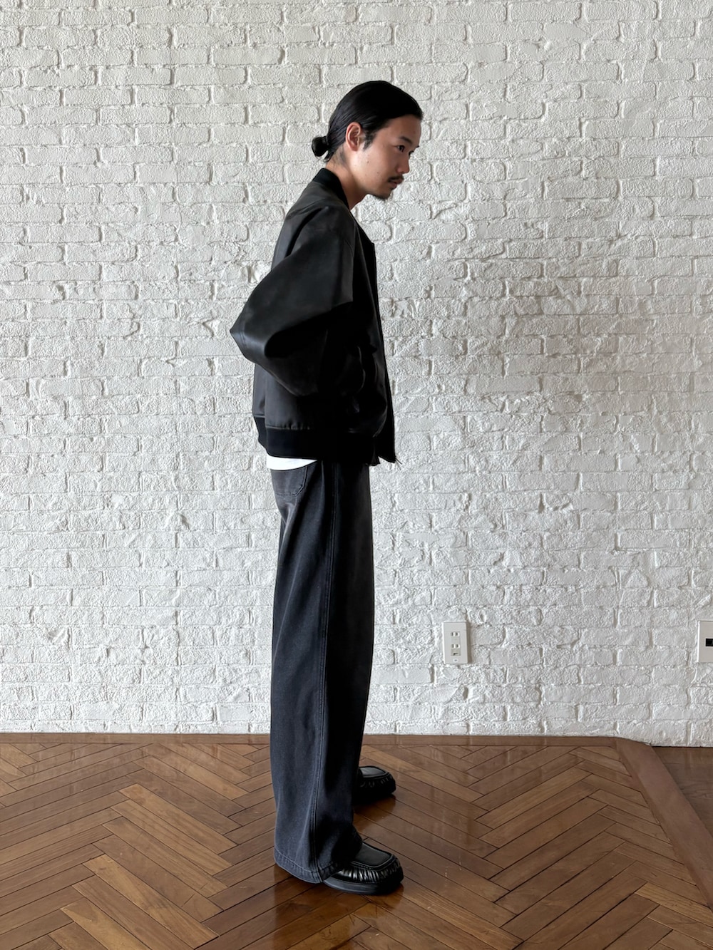 ブラック系のブルゾン、グレー系のセットアップを着用したメンズの夏コーディネートの2枚目の写真