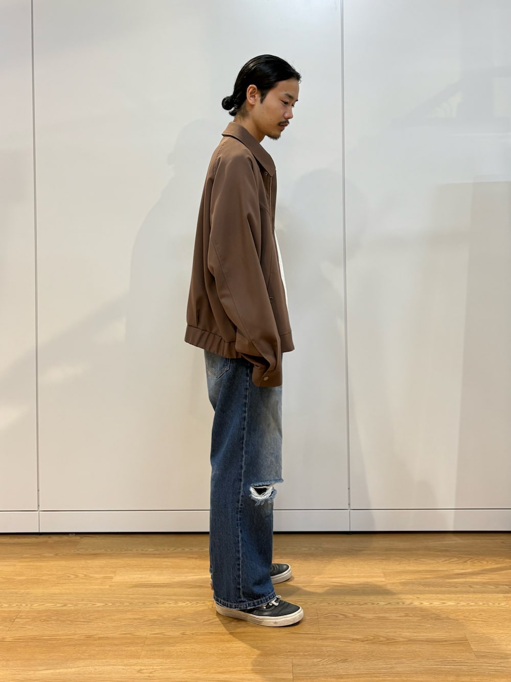 ブルー系のデニムパンツ、ブラウン系のブルゾンを着用したメンズの夏コーディネートの2枚目の写真