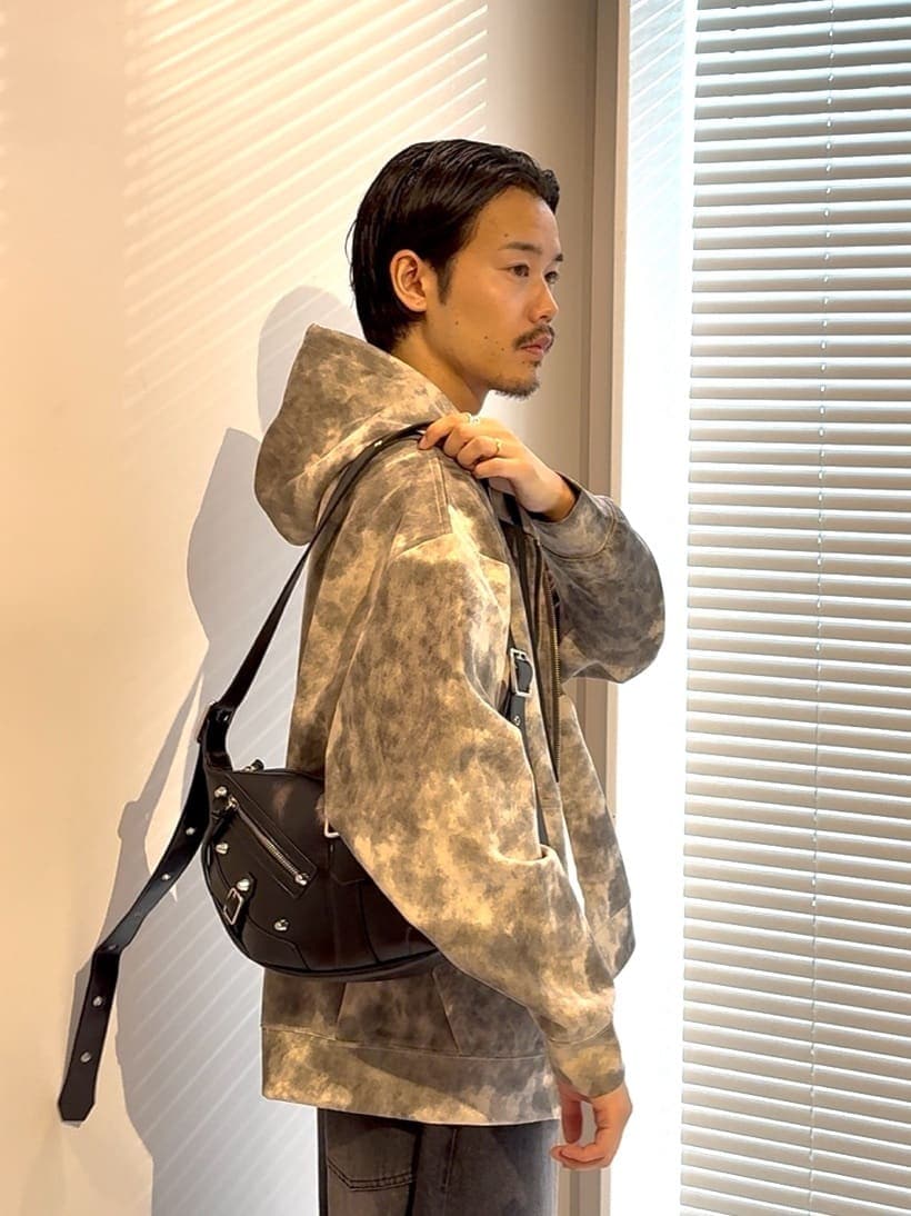 ブラウン系のパーカー、ブルー系のドレスシューズ、ブラック系のショルダーバッグを着用したメンズの夏コーディネートの3枚目の写真