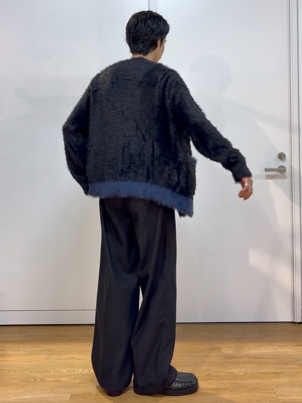 ブラック系のカーディガン/ボレロ、ブラック系のデニムパンツを着用したメンズの秋コーディネートの2枚目の写真