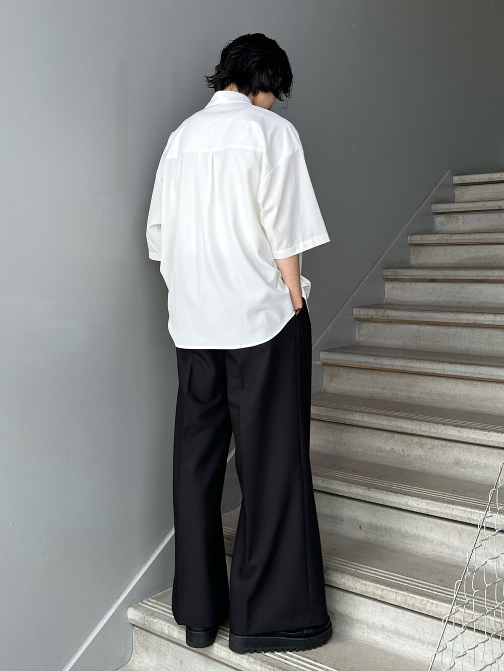 ホワイト系のシャツ/ブラウス、ブラック系のスラックス、ブラック系のサンダルを着用したメンズの夏コーディネートの2枚目の写真