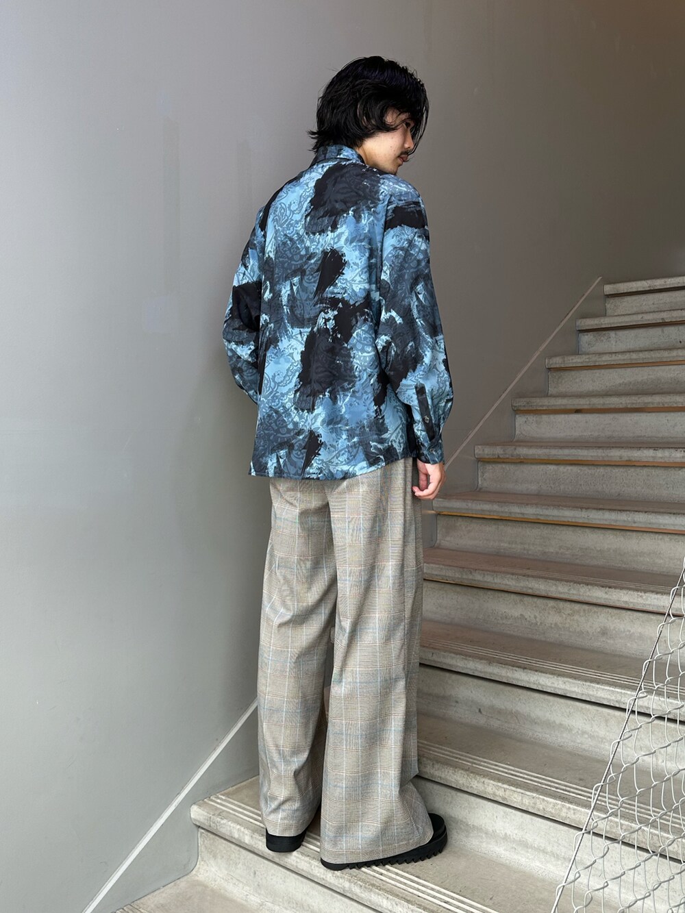 ブルー系のシャツ/ブラウス、ベージュ系のスラックス、ブラック系のサンダルを着用したメンズの夏コーディネートの2枚目の写真