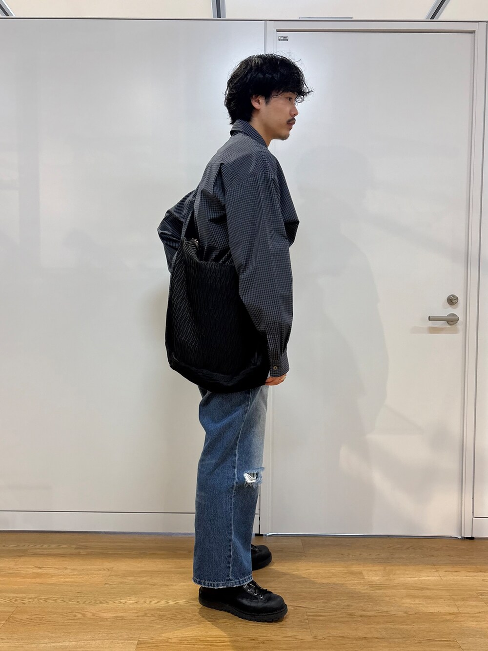 ブルー系のシャツ/ブラウス、ブラック系のショルダーバッグを着用したメンズの春コーディネートの2枚目の写真