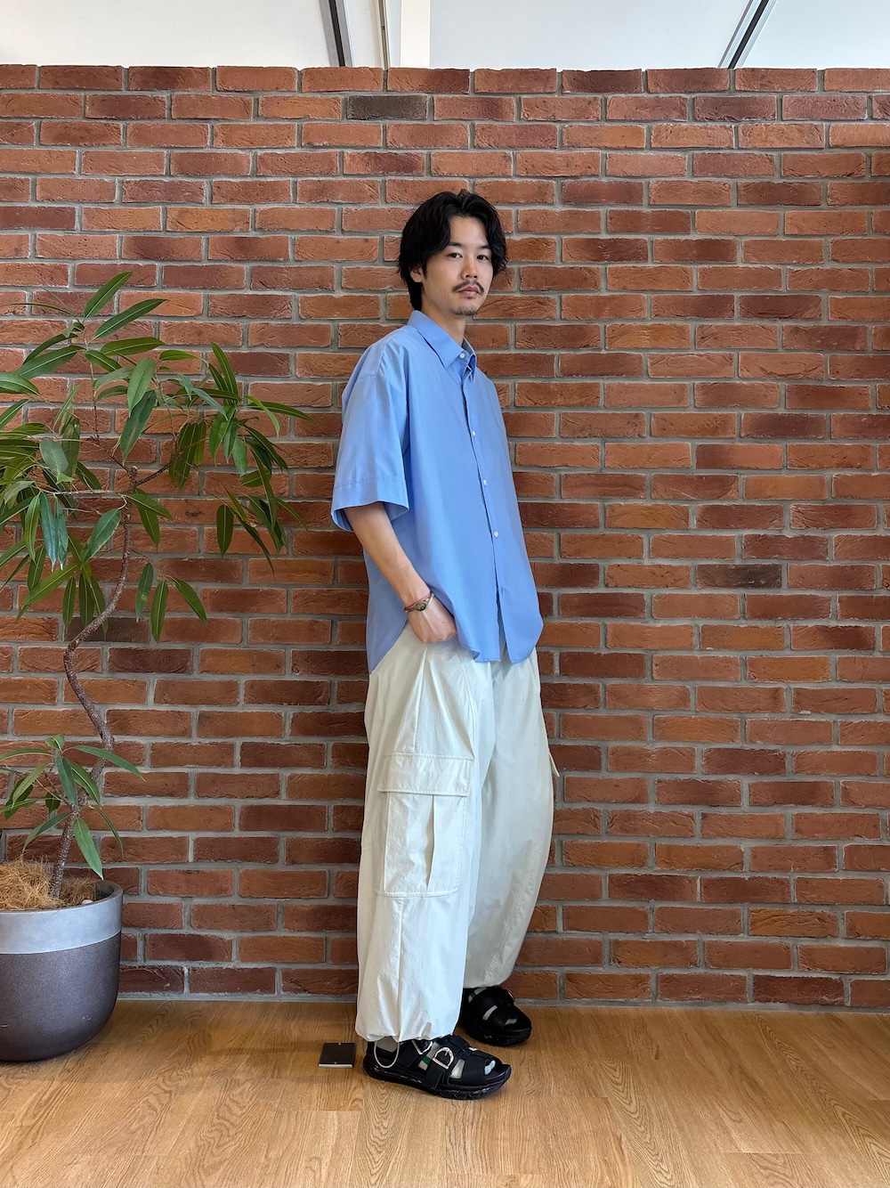 ブルー系のシャツ/ブラウス、ホワイト系のカーゴパンツ、ブラック系のサンダルを着用したメンズの春コーディネートの2枚目の写真