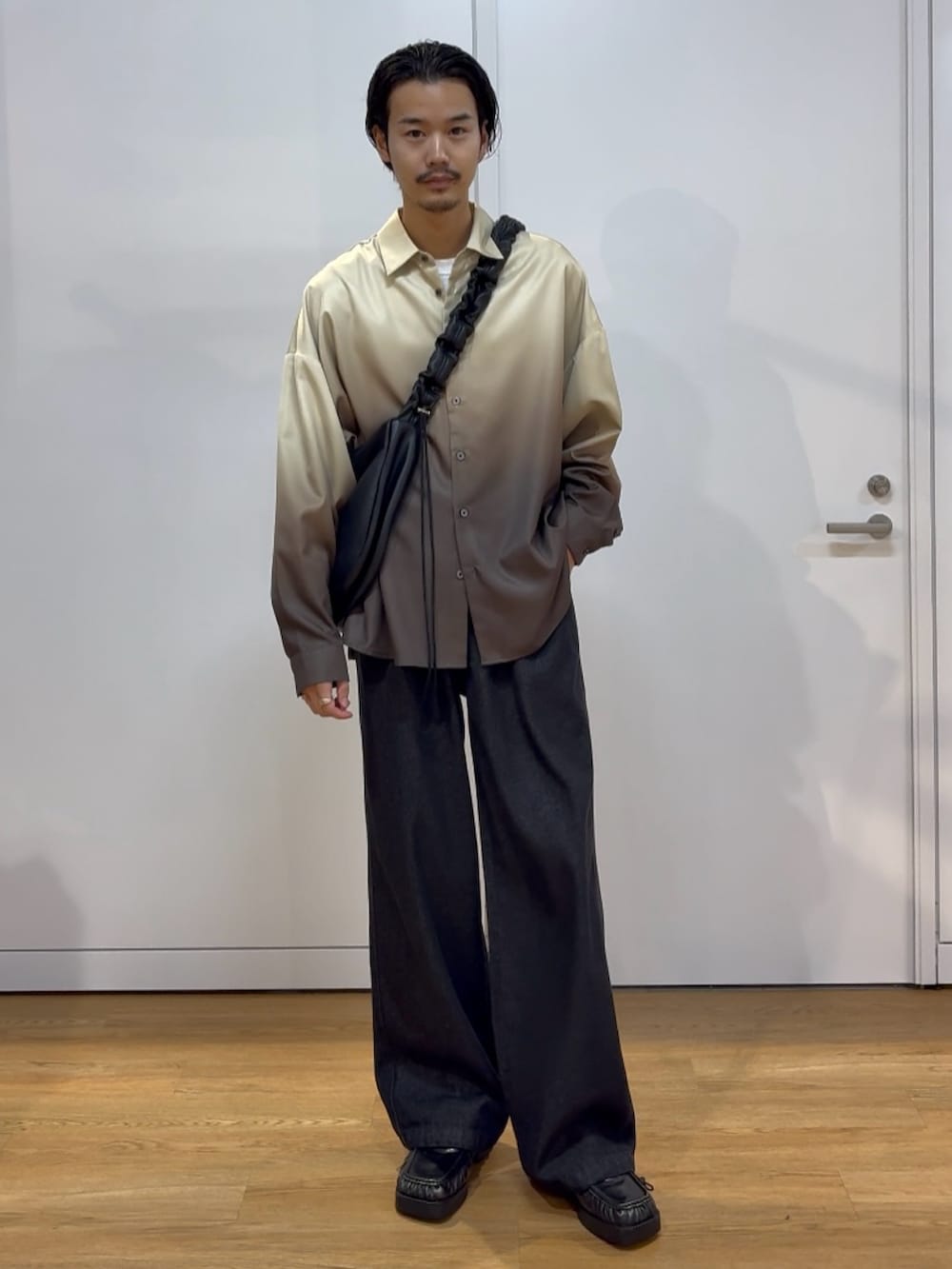 ブラック系のショルダーバッグ、ブラウン系のシャツ/ブラウス、ブラック系のデニムパンツを着用したメンズの秋コーディネートの2枚目の写真