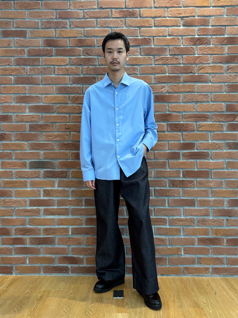 ブルー系のビジネスシャツ、ブルー系のデニムパンツ、ブラック系のドレスシューズを着用したメンズの夏コーディネートの2枚目の写真
