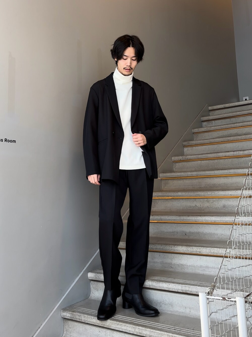 ブラック系のセットアップ、ブラック系のブーツを着用したメンズの冬コーディネートの2枚目の写真