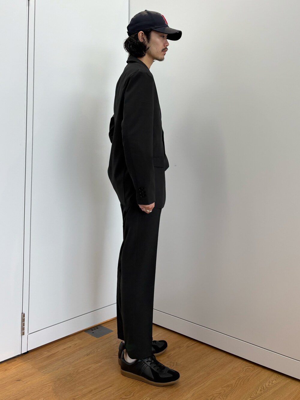 ブラック系のセットアップ、ブラック系のスニーカーを着用したメンズの春コーディネートの4枚目の写真