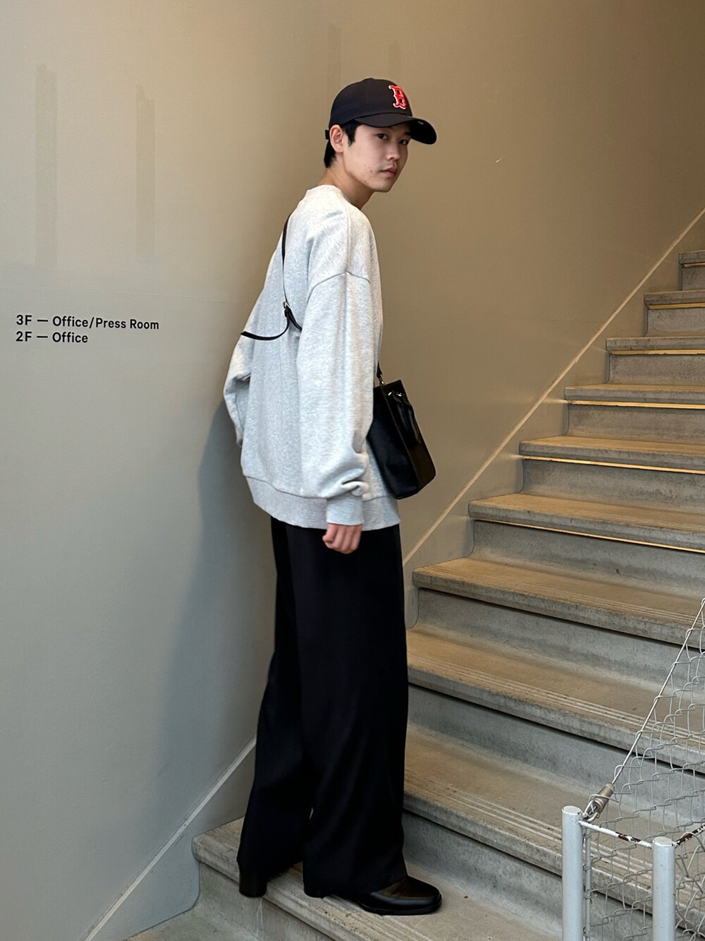 グレー系のスウェット、ブラック系のショルダーバッグ、ブラック系のその他パンツを着用したメンズの冬コーディネートの3枚目の写真