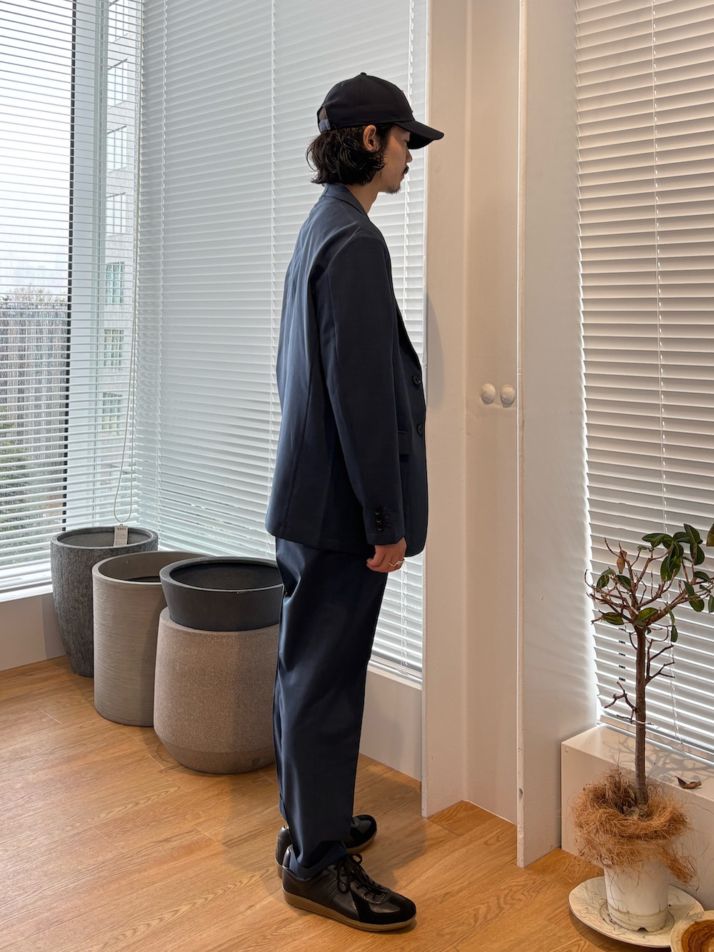 ブルー系のセットアップ、ブラック系のスニーカーを着用したメンズの春コーディネートの2枚目の写真