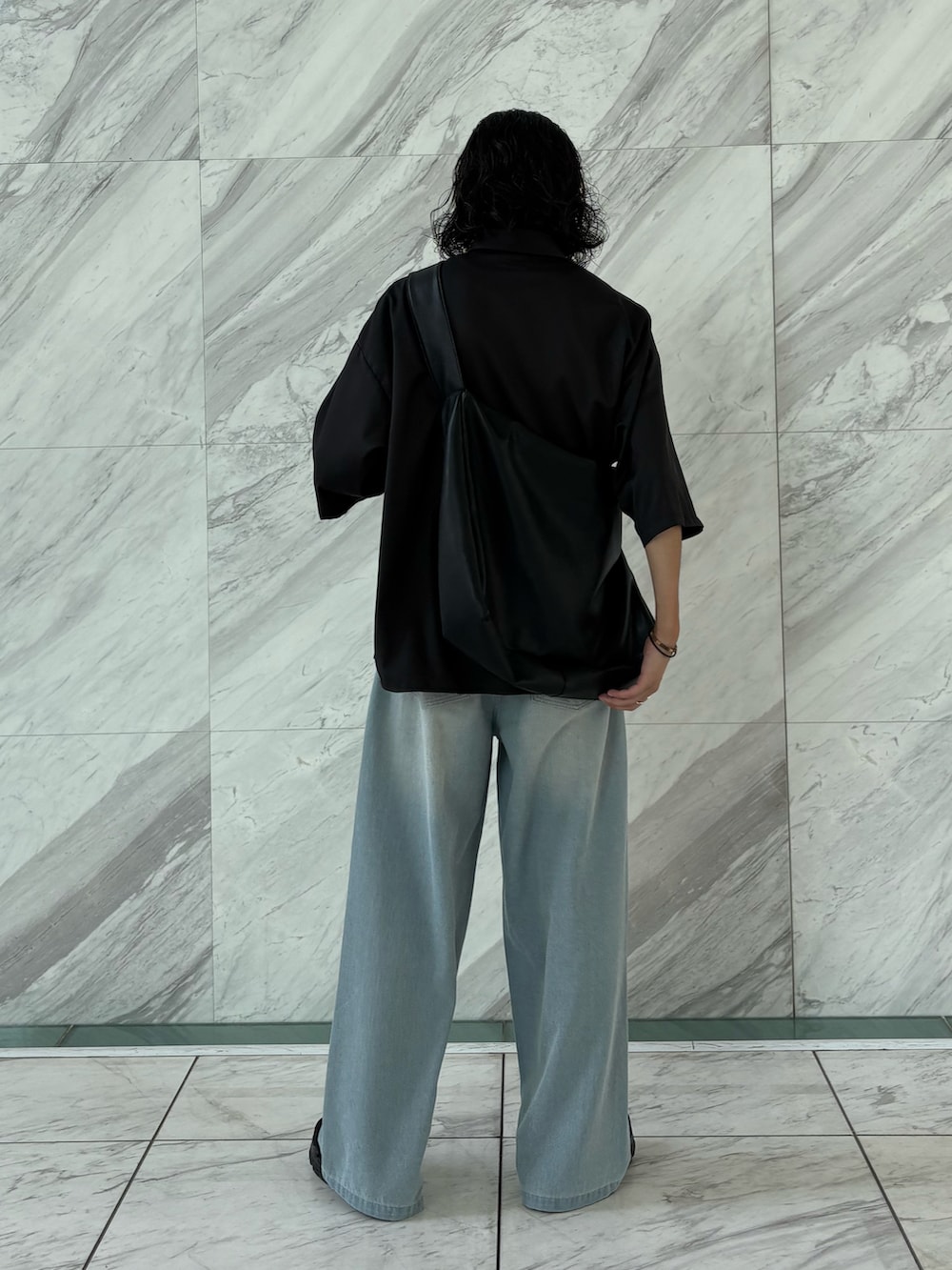 ブラック系のショルダーバッグ、ブラック系のシャツ/ブラウス、ブルー系のデニムパンツを着用したメンズの夏コーディネートの3枚目の写真