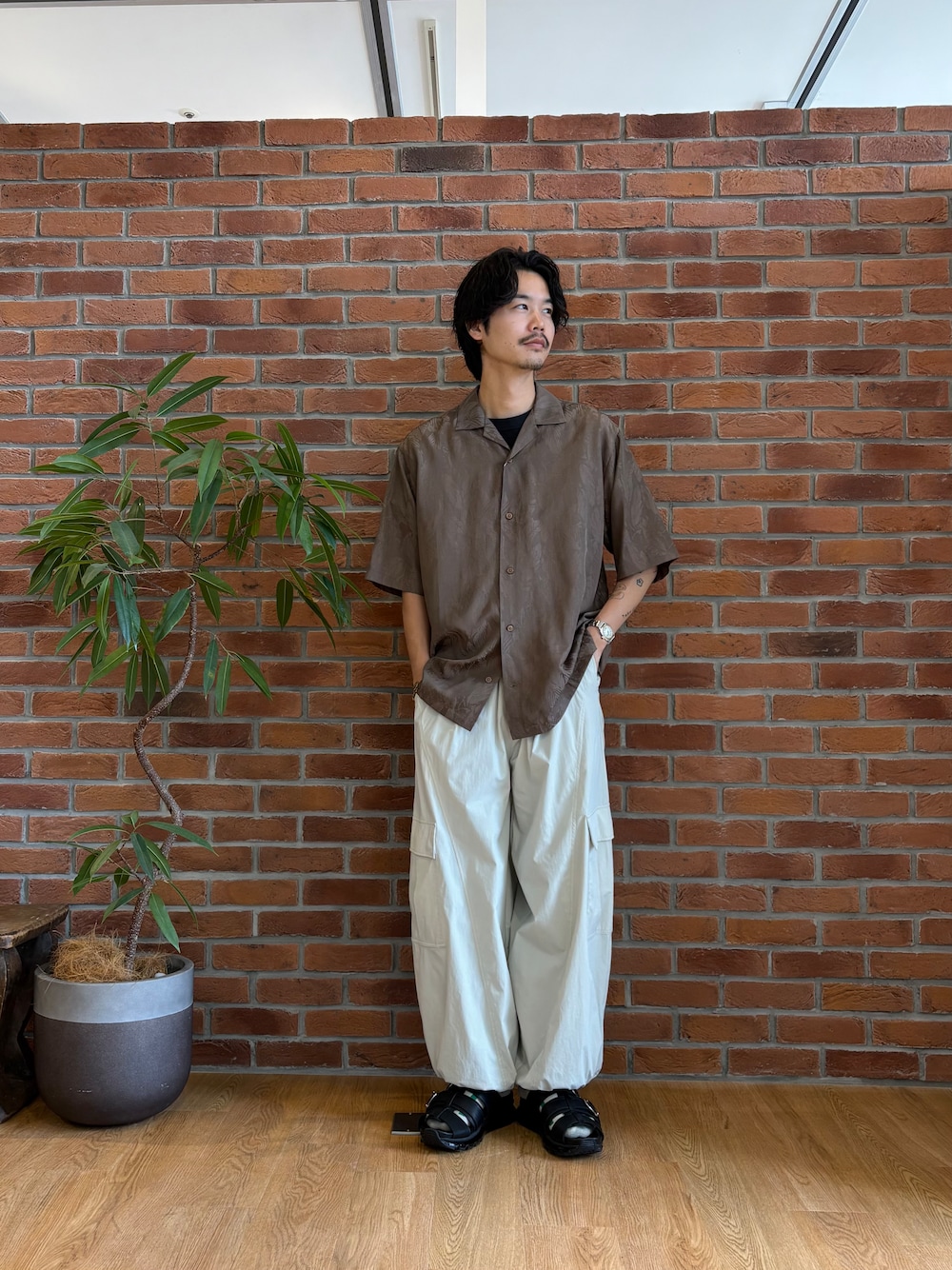 ブラウン系のシャツ/ブラウス、ホワイト系のカーゴパンツ、ブラック系のサンダルを着用したメンズの春コーディネートの2枚目の写真