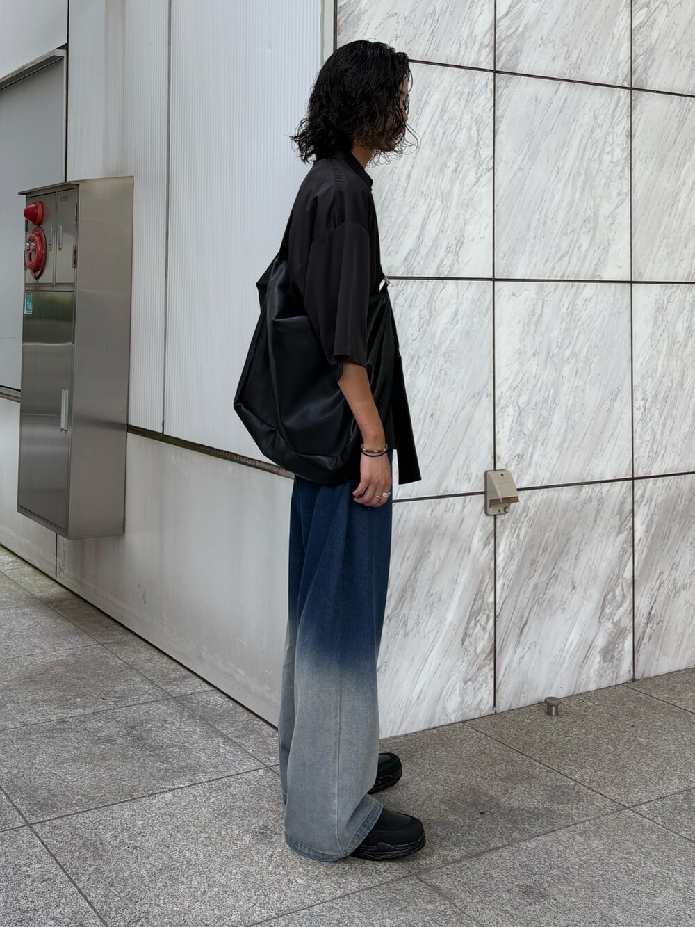 ブラック系のショルダーバッグ、ブラック系のシャツ/ブラウス、ブルー系のデニムパンツを着用したメンズの夏コーディネートの3枚目の写真