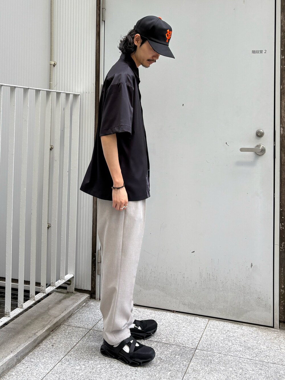 ブラック系のシャツ/ブラウス、ベージュ系のその他パンツ、ブラック系のサンダルを着用したメンズの春コーディネートの3枚目の写真