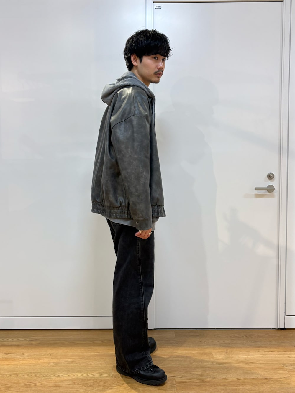 ブラック系のブルゾン、グレー系のパーカーを着用したメンズの春コーディネートの2枚目の写真