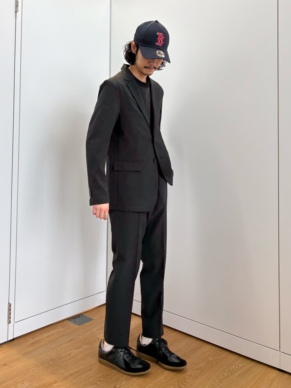 ブラック系のセットアップ、ブラック系のスニーカーを着用したメンズの春コーディネートの5枚目の写真