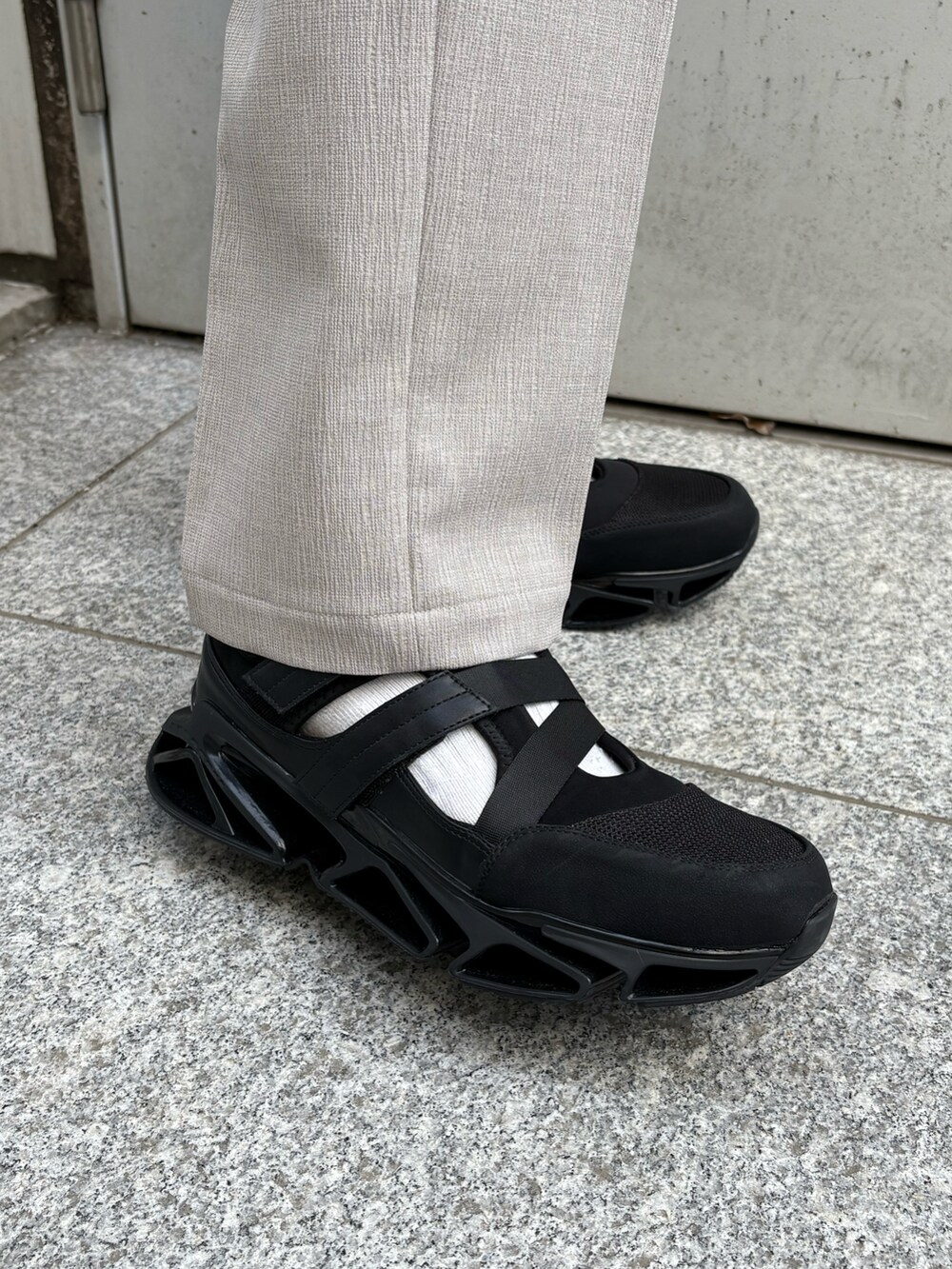 ブラック系のシャツ/ブラウス、ベージュ系のその他パンツ、ブラック系のサンダルを着用したメンズの春コーディネートの5枚目の写真