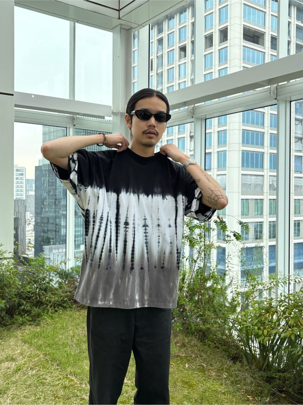 ブラック系のTシャツ/カットソーを着用したメンズの春コーディネートの2枚目の写真