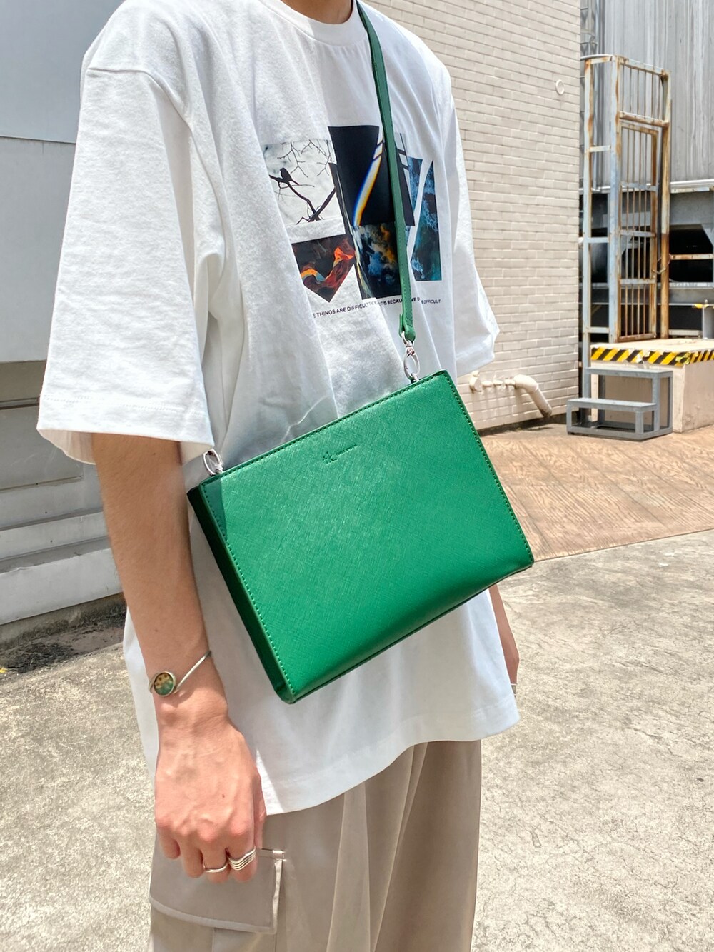 ホワイト系のTシャツ/カットソー、グリーン系のショルダーバッグ、ベージュ系のその他パンツを着用したメンズの夏コーディネートの3枚目の写真