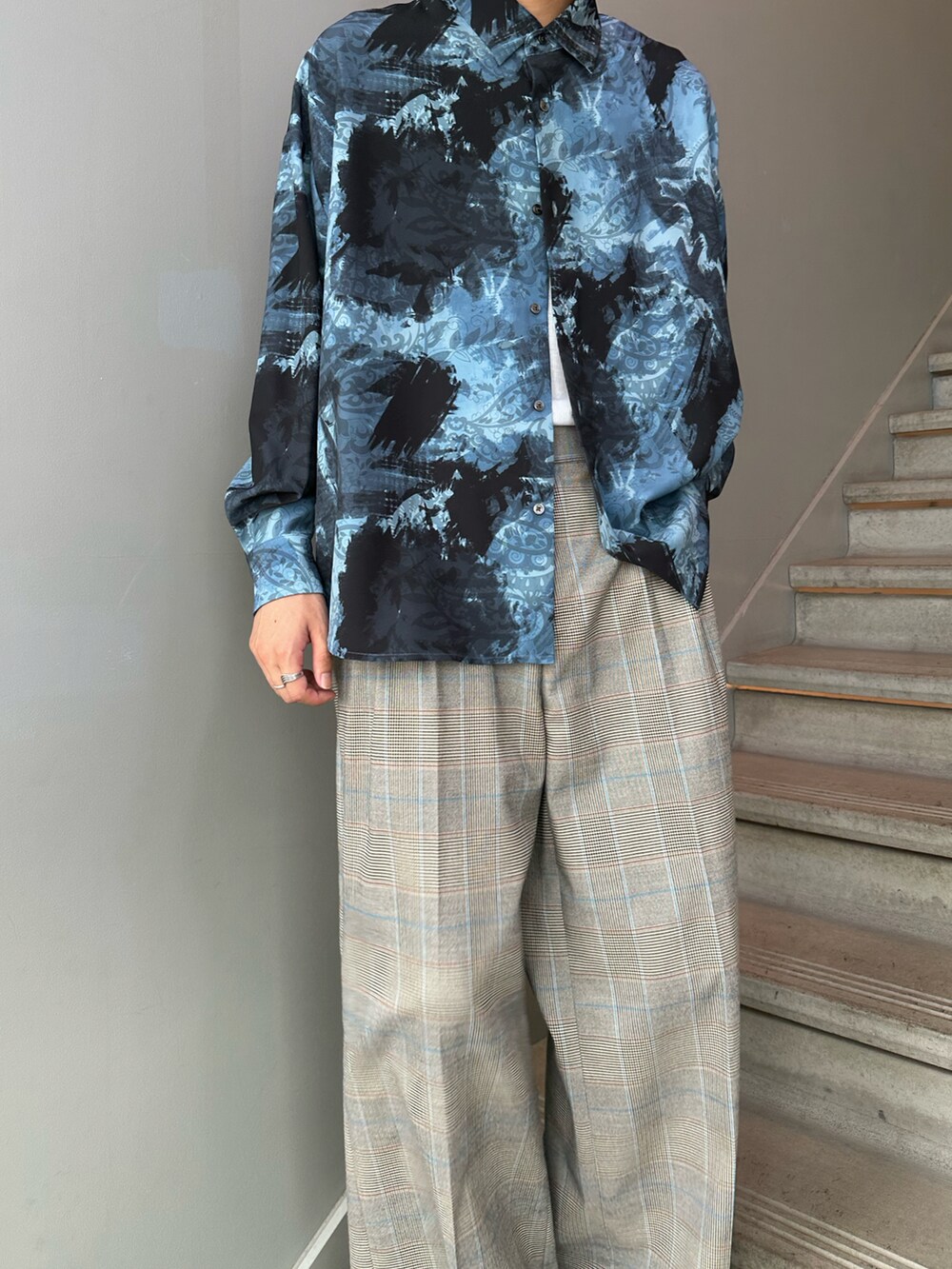 ブルー系のシャツ/ブラウス、ベージュ系のスラックス、ブラック系のサンダルを着用したメンズの夏コーディネートの3枚目の写真