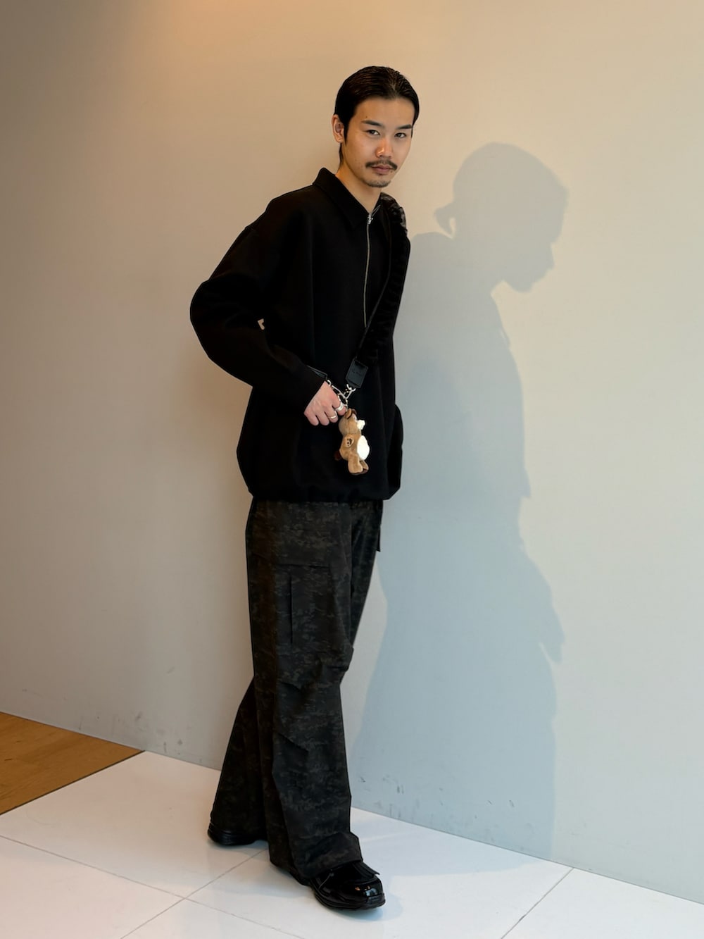 ブラック系のTシャツ/カットソー、ブラック系のその他シューズ、ブラック系のその他小物を着用したメンズの冬コーディネートの2枚目の写真