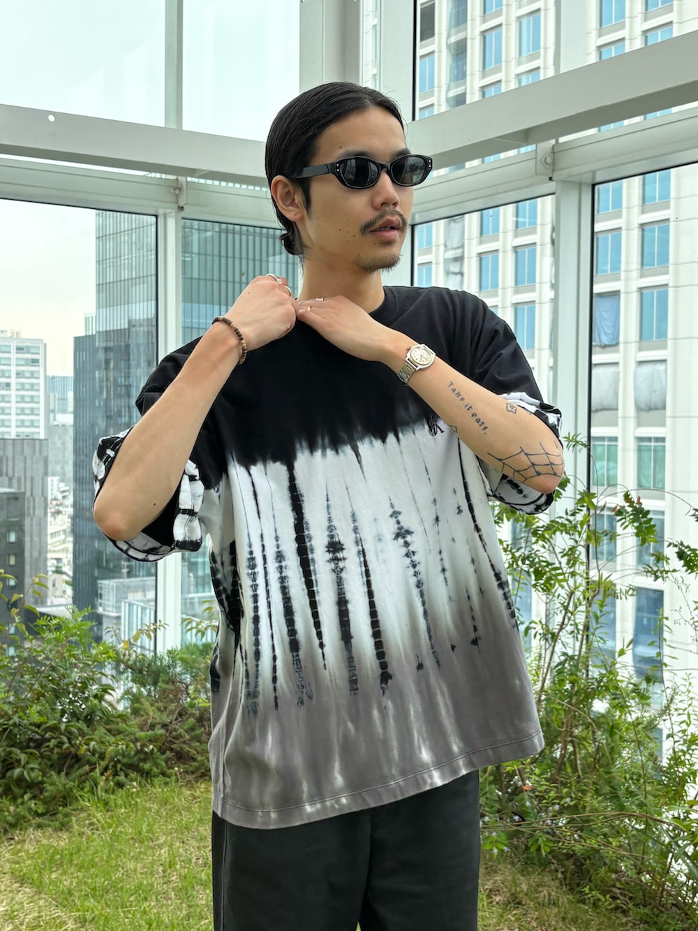 ブラック系のTシャツ/カットソーを着用したメンズの春コーディネートの2枚目の写真