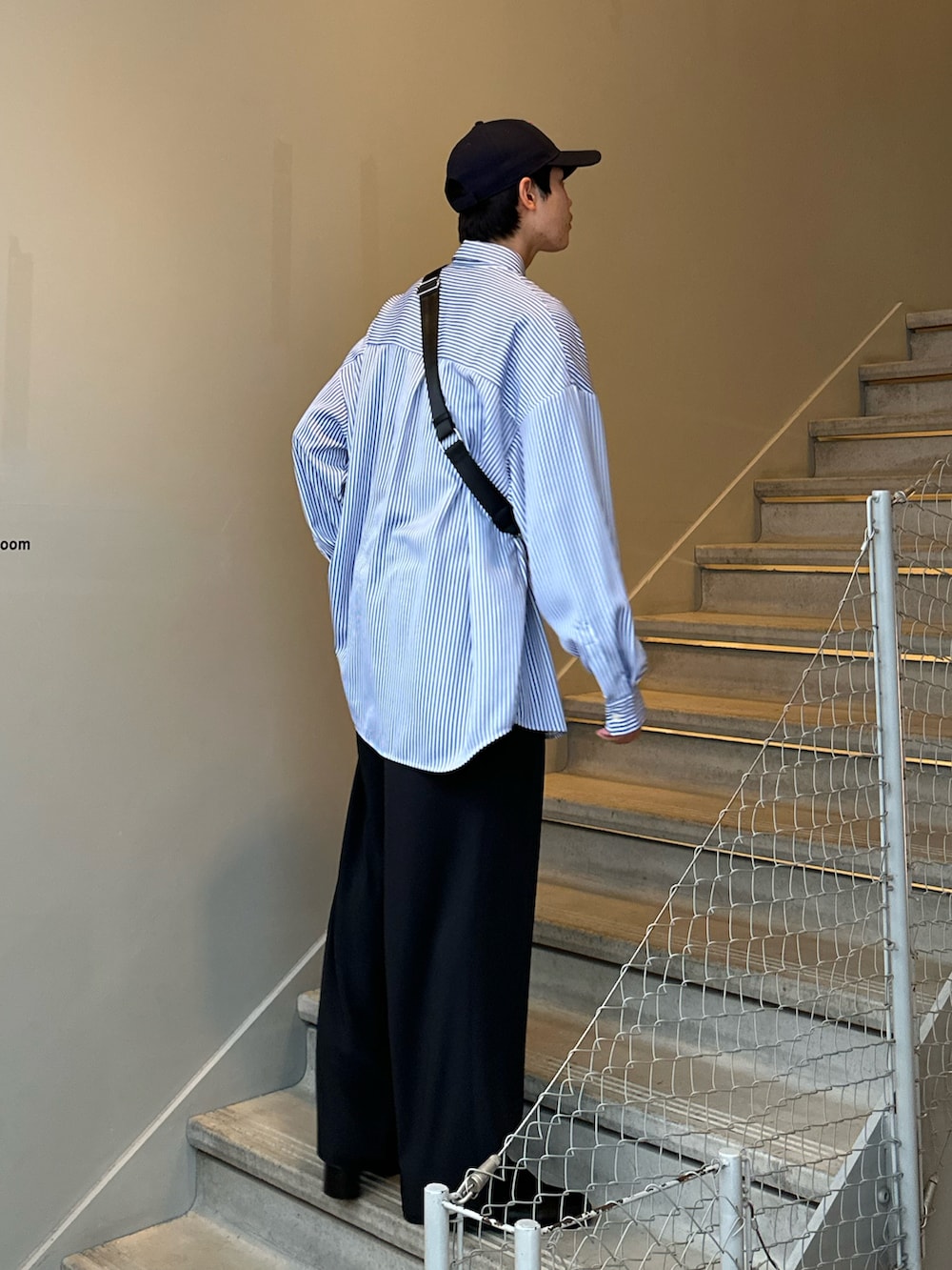 ブラック系のその他パンツ、ブラック系のブーツ、ブラック系のショルダーバッグを着用したメンズの冬コーディネートの3枚目の写真