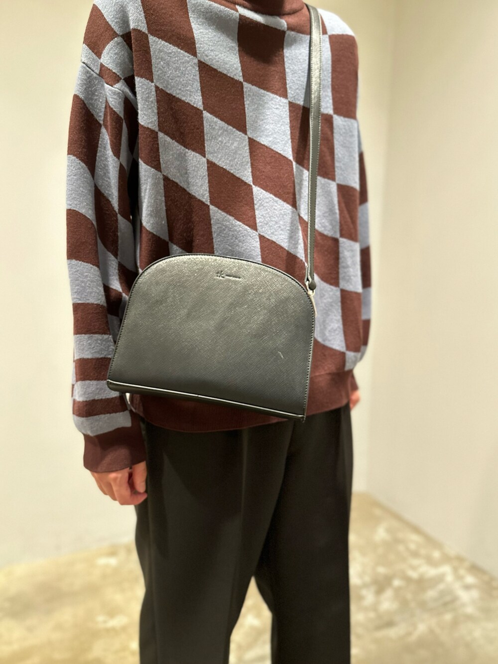 ブラウン系のニット/セーター、ブラック系のショルダーバッグ、ブラック系のその他パンツを着用したメンズの秋コーディネートの2枚目の写真