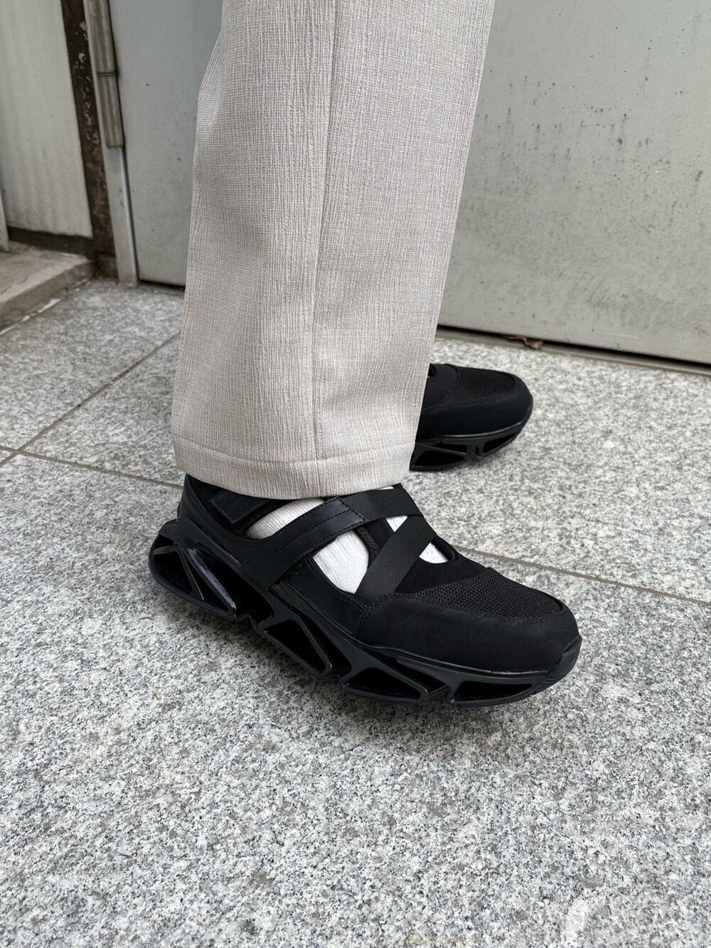 ブラック系のシャツ/ブラウス、ベージュ系のその他パンツ、ブラック系のサンダルを着用したメンズの春コーディネートの5枚目の写真