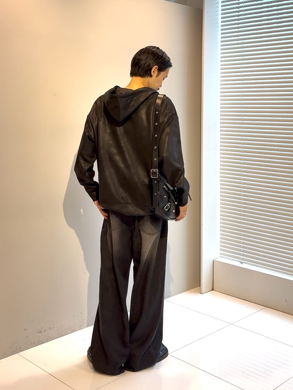 ブラック系のパーカー、ブラック系のデニムパンツ、ブラック系のショルダーバッグを着用したメンズの夏コーディネートの3枚目の写真