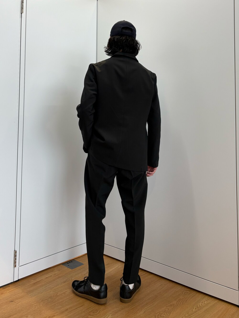 ブラック系のセットアップ、ブラック系のスニーカーを着用したメンズの春コーディネートの2枚目の写真