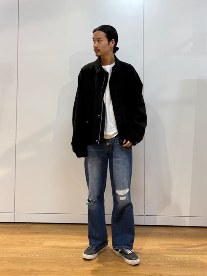 ブラック系のブルゾン、ブルー系のデニムパンツを着用したメンズの夏コーディネートの2枚目の写真