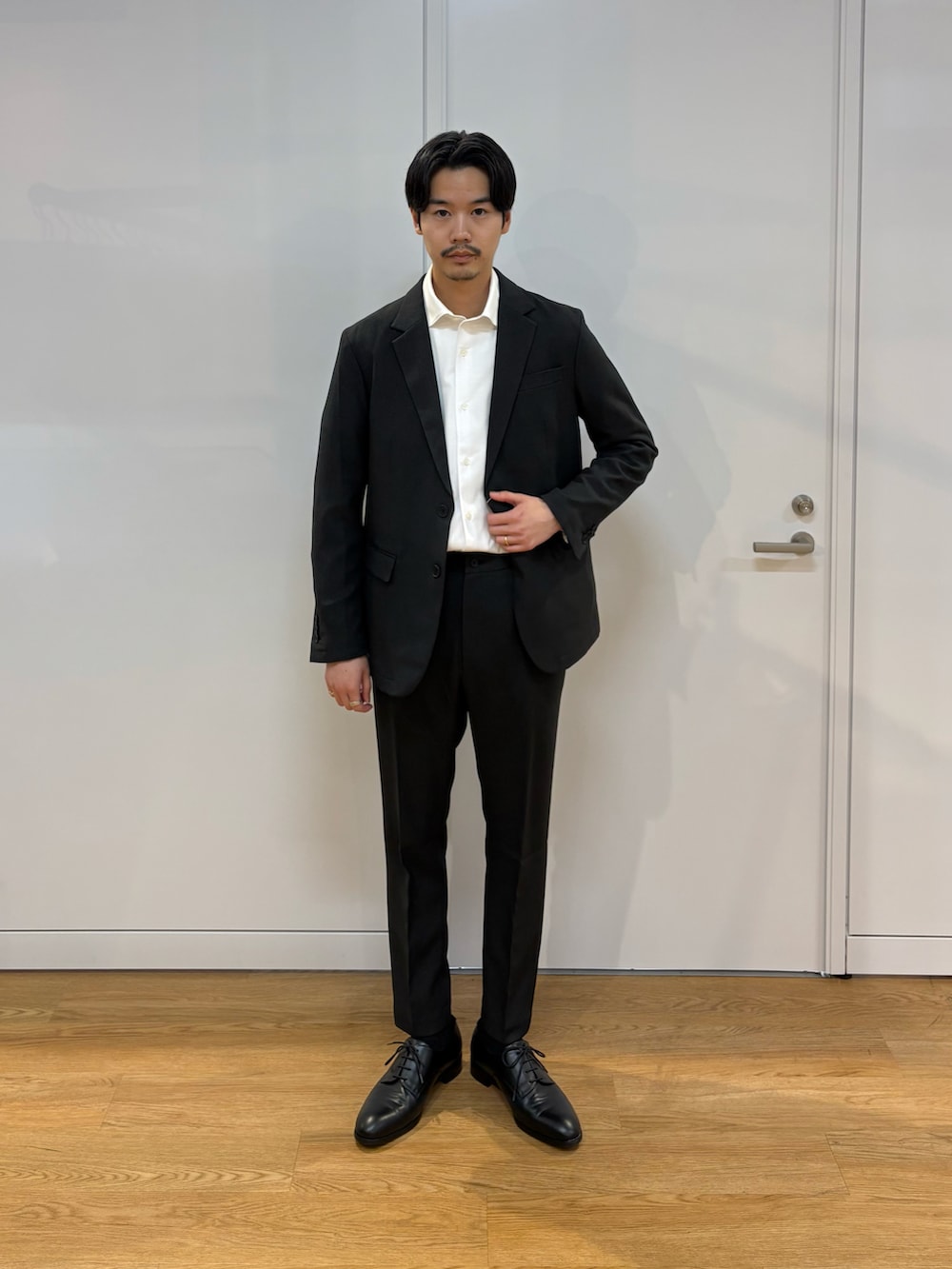 ブラック系のセットアップ、ブラック系のドレスシューズを着用したメンズの春コーディネートの2枚目の写真