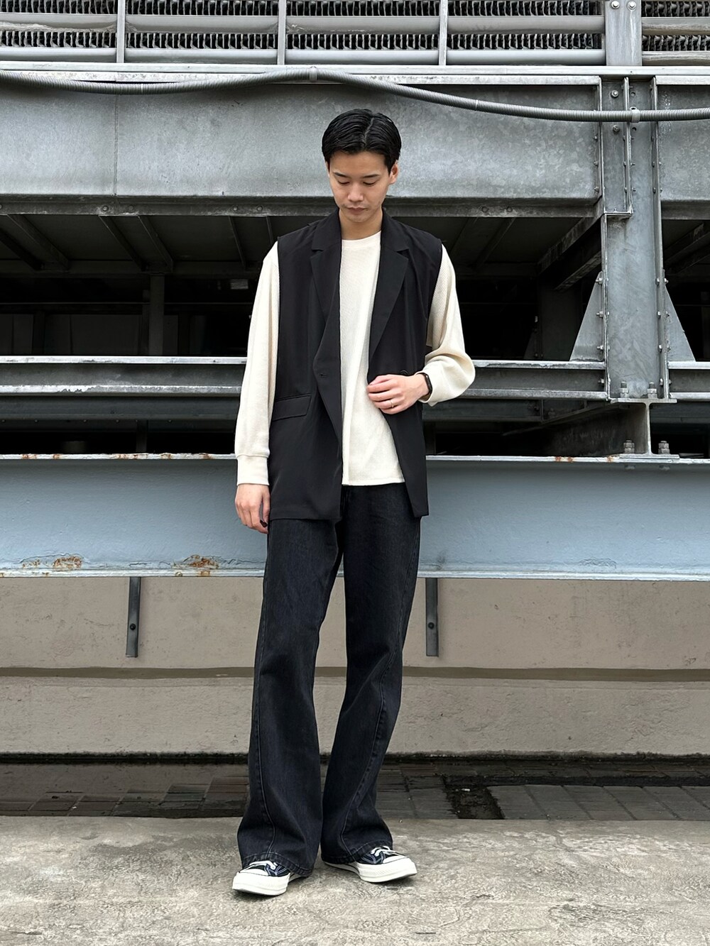 ブラック系のベスト、ブラック系のデニムパンツを着用したメンズの春コーディネートの2枚目の写真