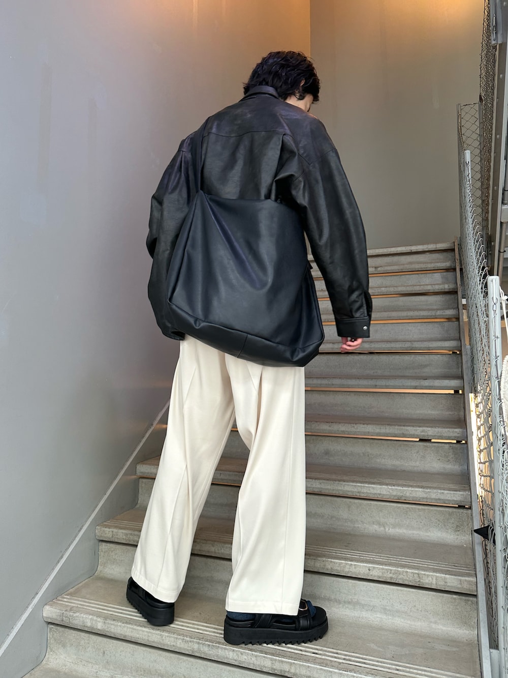 ホワイト系のスラックス、ブラック系のサンダル、ブラック系のショルダーバッグを着用したメンズの夏コーディネートの2枚目の写真